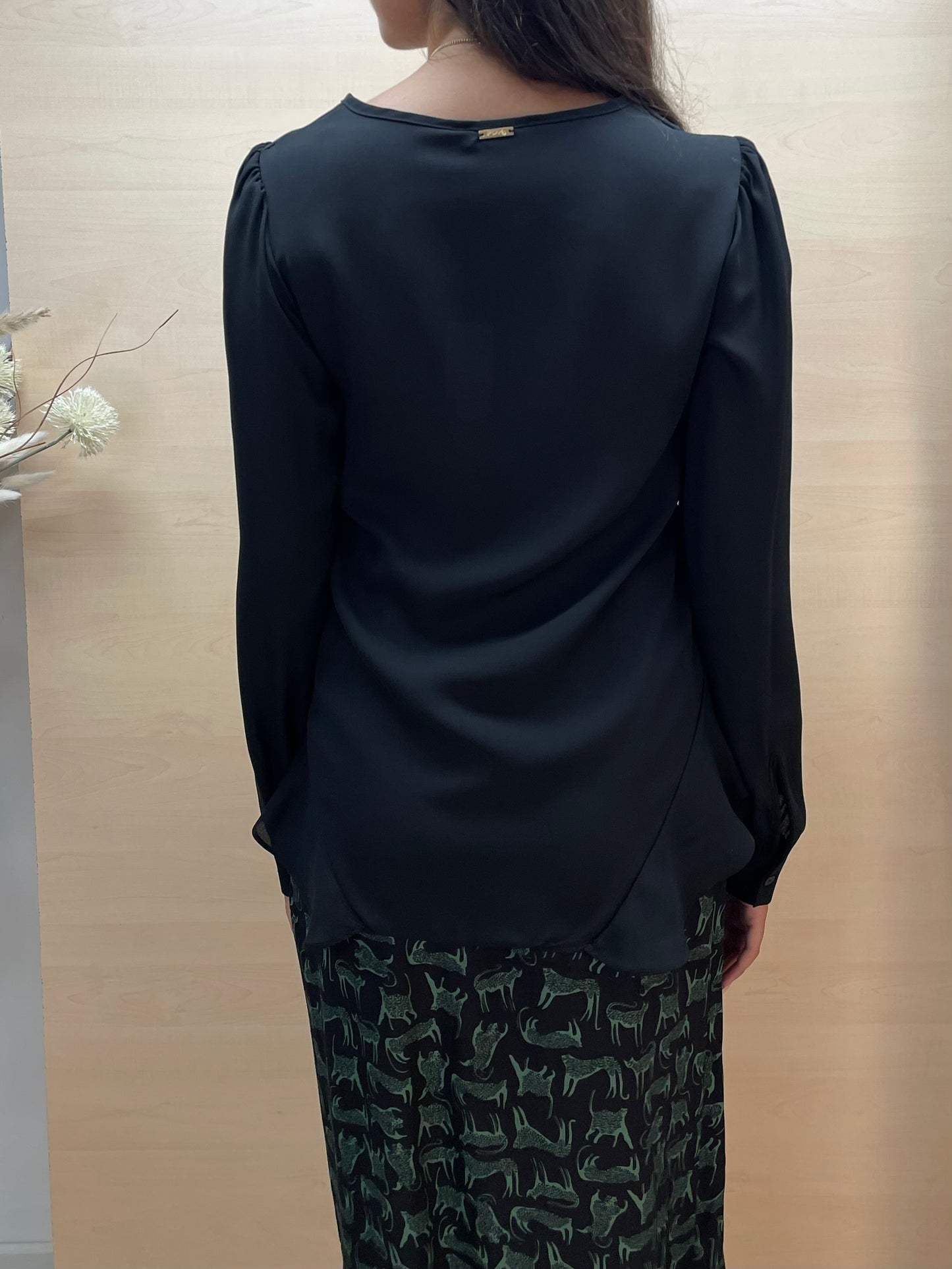 Blusa nera con drappeggio e volant frontali