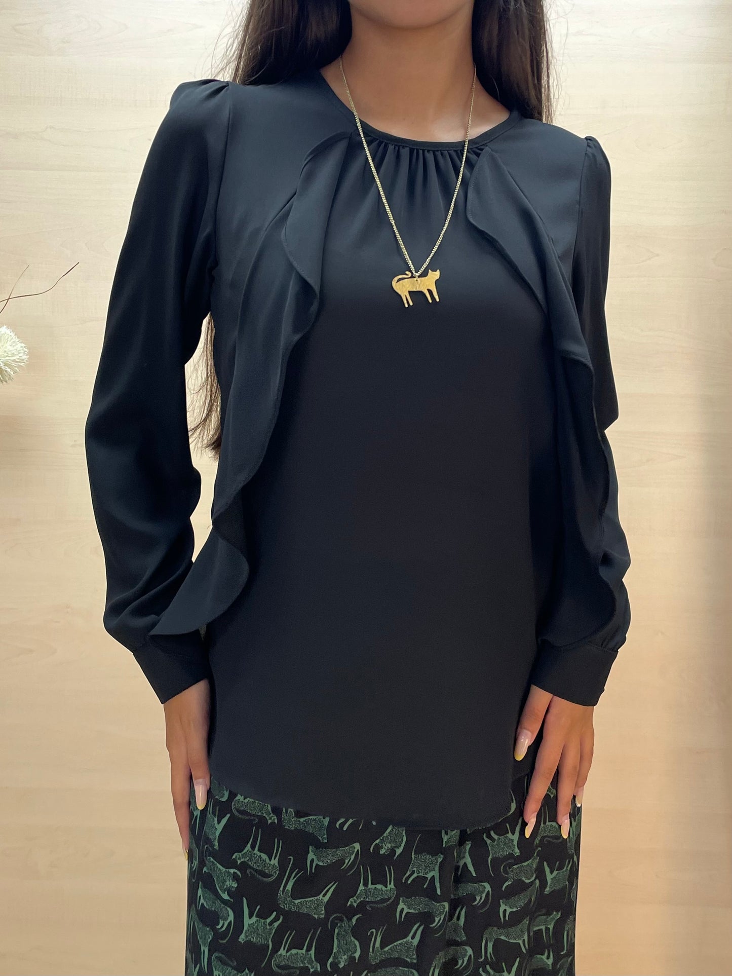 Blusa nera con drappeggio e volant frontali