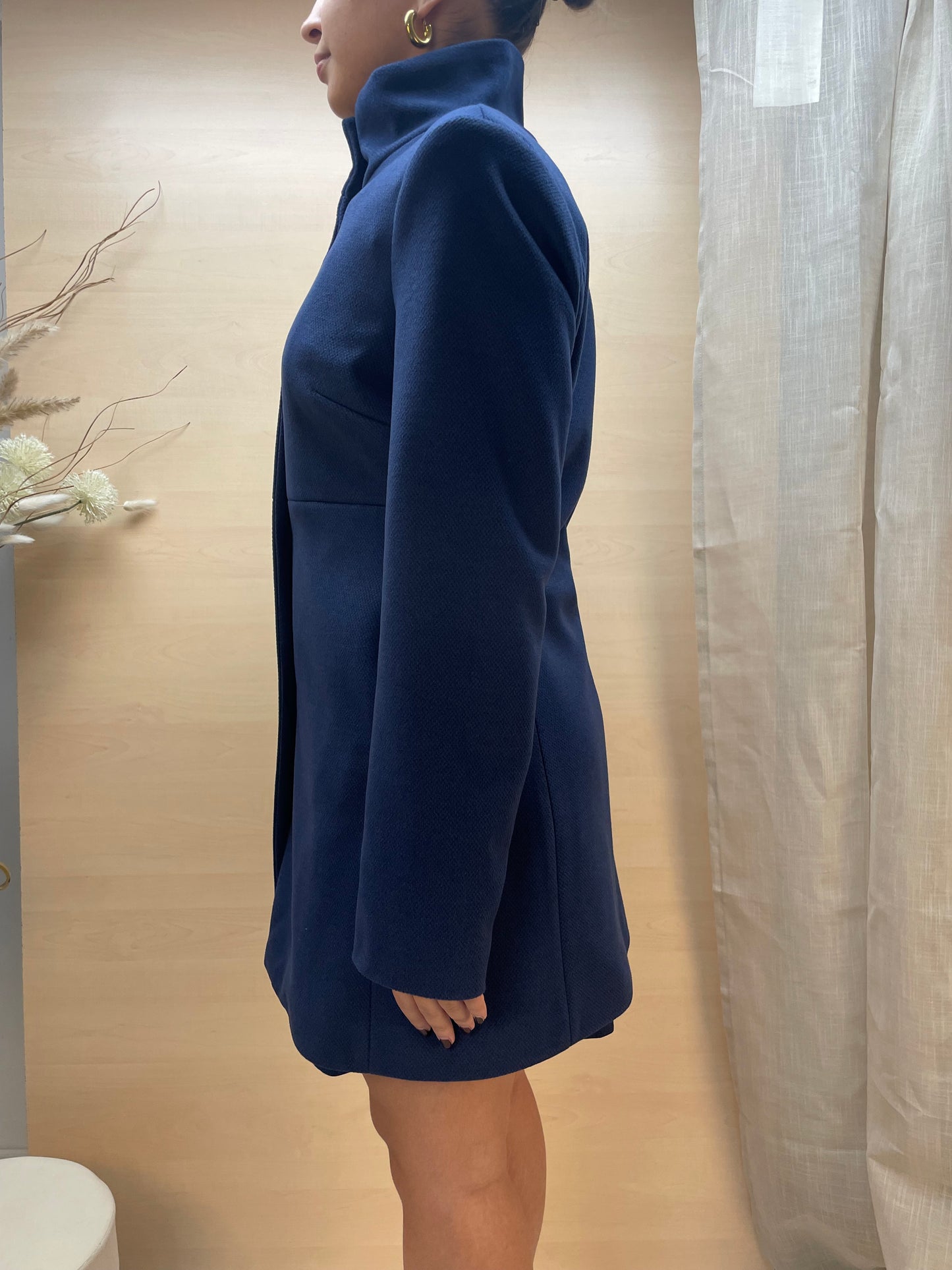 Cappotto blu con collo alto e chiusura a bottoni