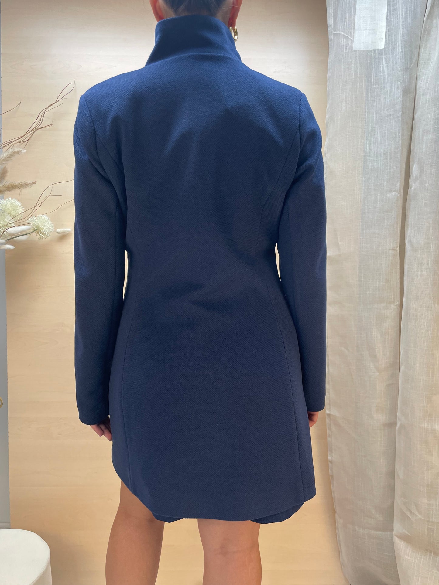 Cappotto blu con collo alto e chiusura a bottoni