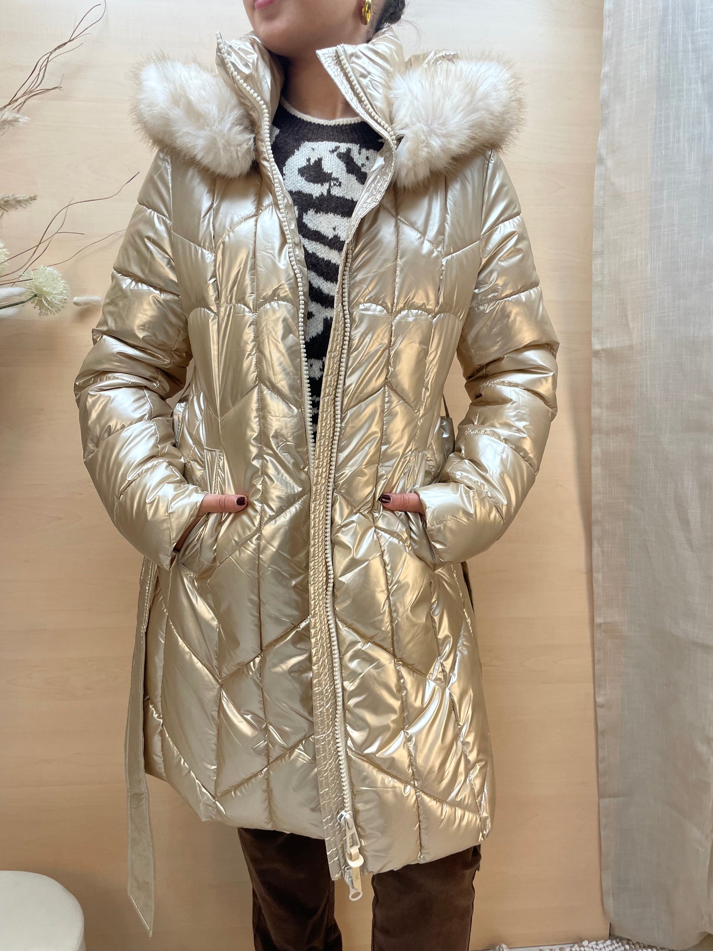 Piumino lungo color gold con cintura e cappuccio in eco-pelliccia