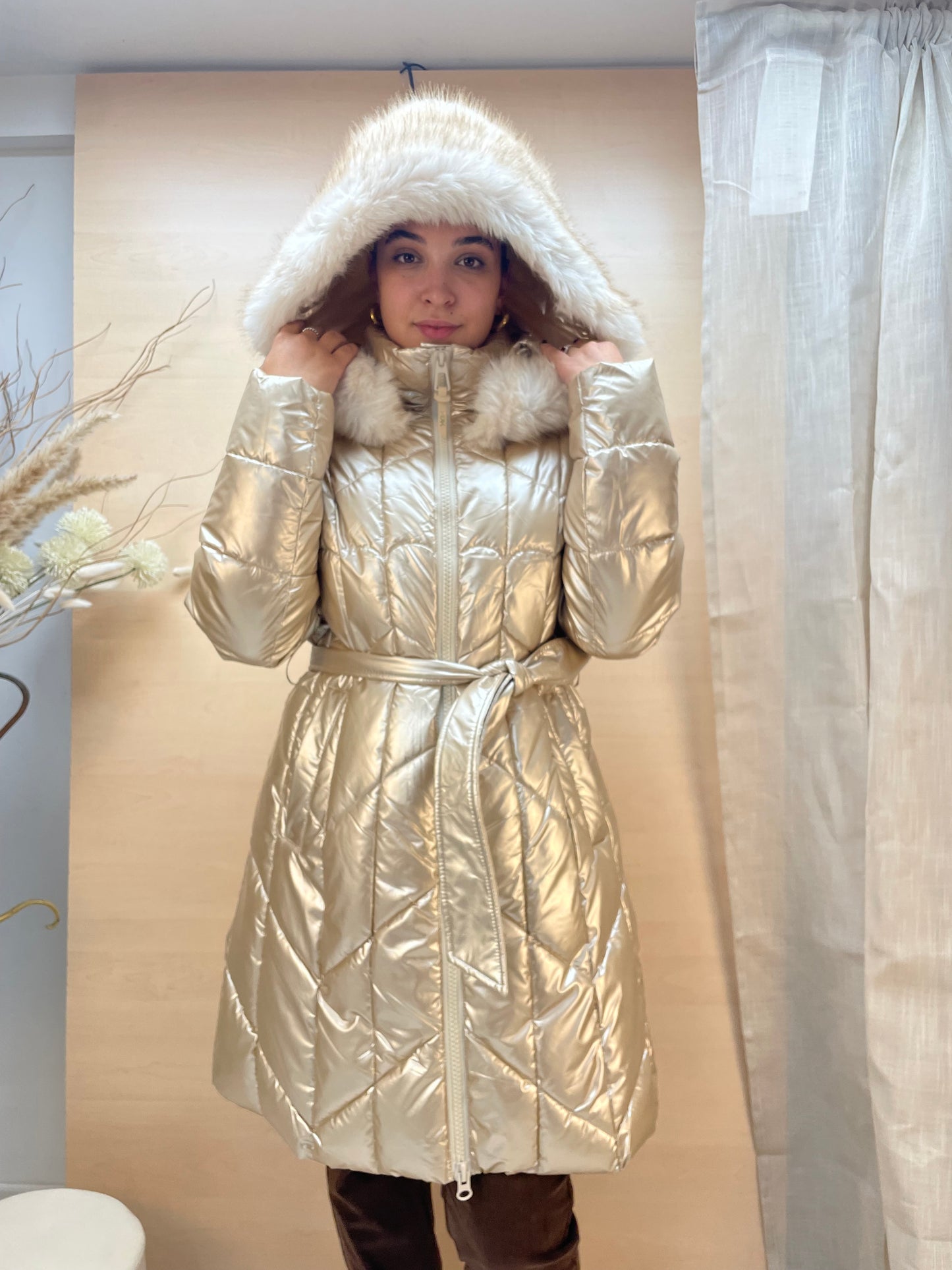 Piumino lungo color gold con cintura e cappuccio in eco-pelliccia
